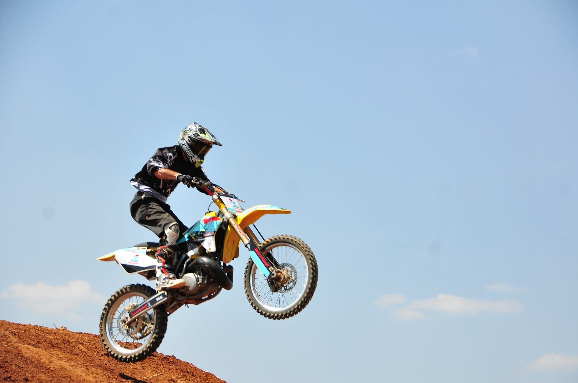Pilote de motocross en plein saut sur la terre rouge