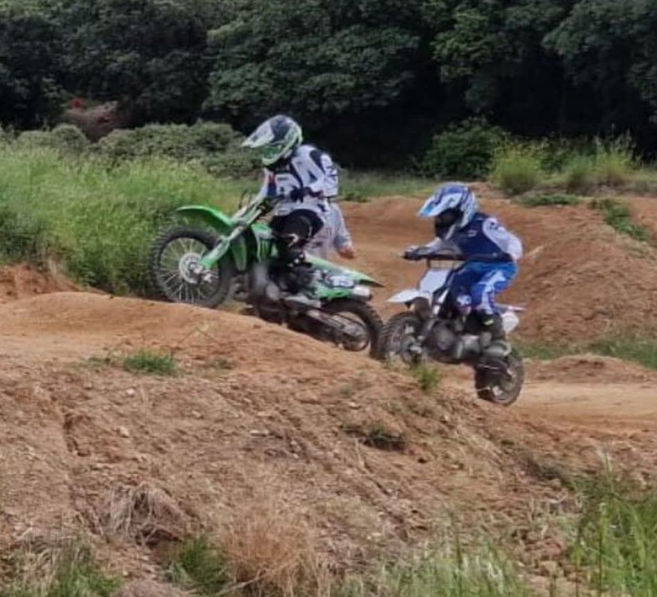 Deux jeunes pilotes en plein saut sur une bosse du circuit pendant un stage